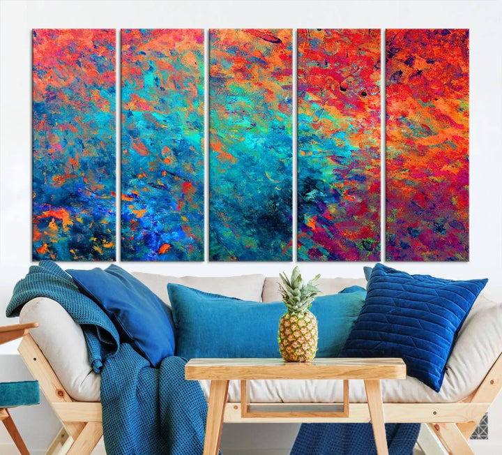 A three-part Colorful Abstract Canvas Wall Art Print, featuring vivid splashes of blue, orange, and red, is showcased on gallery-wrapped, museum-quality canvas with a UV-protective coating.