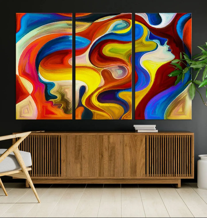 The Colorful Abstract Human Figure Wall Art Canvas Print, featuring overlapping human profiles on museum-quality canvas, is exhibited as a triptych.