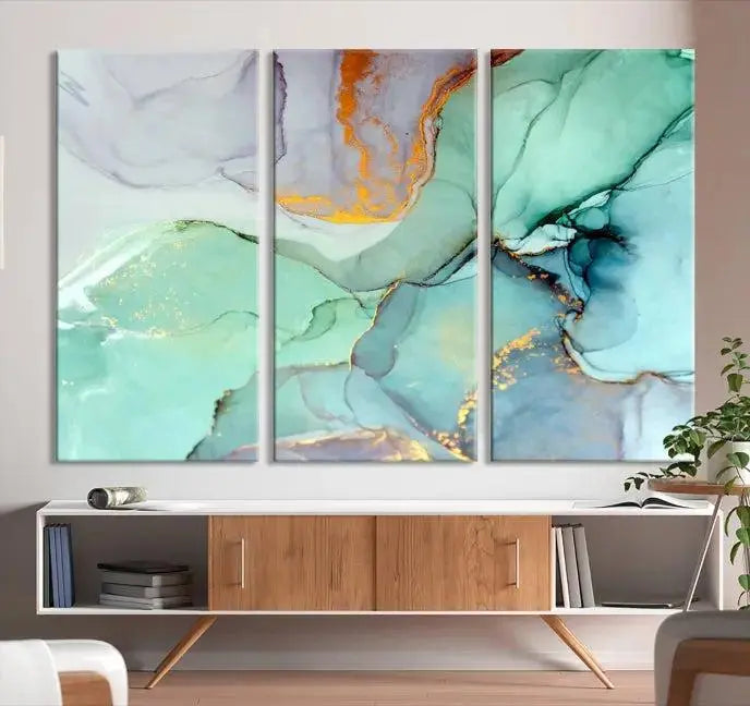 Contemporary living room featuring the Colorful Marble Fluid Effect Wall Art Abstract Canvas Wall Art Print, showcasing multi-panel abstract designs in teal, gold, and white tones. This museum-quality canvas artwork is ready to hang and finished with a UV-protective coating for enduring vibrancy.