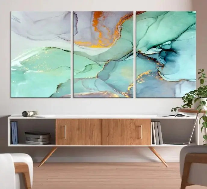 Contemporary living room featuring the Colorful Marble Fluid Effect Wall Art Abstract Canvas Wall Art Print, showcasing multi-panel abstract designs in teal, gold, and white tones. This museum-quality canvas artwork is ready to hang and finished with a UV-protective coating for enduring vibrancy.