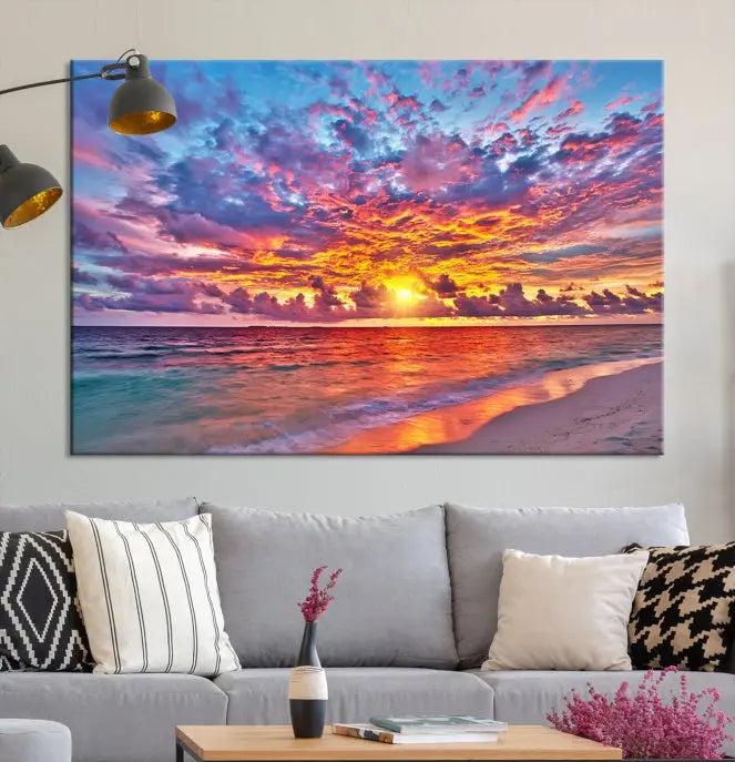 The Colorful Sunset Seashore Wall Art Canvas Print, featuring a triptych of a vibrant ocean sunset on gallery-wrapped museum-quality canvas, adorns the wall.