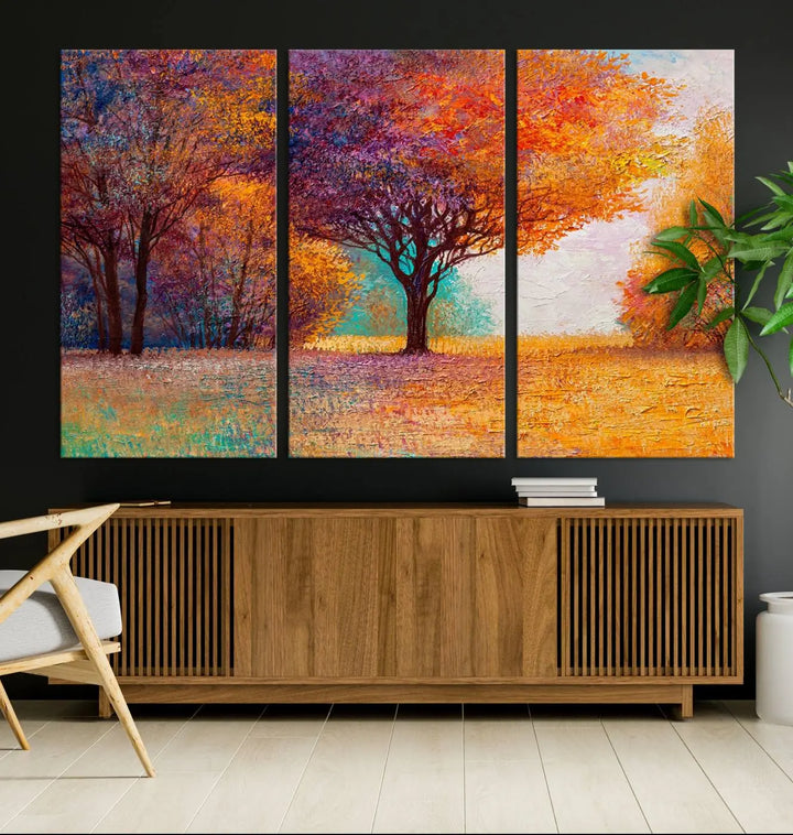 The "Colorful Tree in Autumn" wall art canvas print features a three-panel depiction of a vibrant autumn landscape, gallery wrapped on museum-quality polycotton with UV-protective coating, enhancing the wall in a stylish living room.