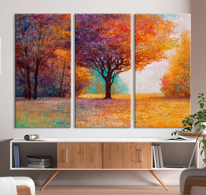 The "Colorful Tree in Autumn" wall art canvas print features a three-panel depiction of a vibrant autumn landscape, gallery wrapped on museum-quality polycotton with UV-protective coating, enhancing the wall in a stylish living room.