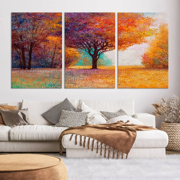 The "Colorful Tree in Autumn" wall art canvas print features a three-panel depiction of a vibrant autumn landscape, gallery wrapped on museum-quality polycotton with UV-protective coating, enhancing the wall in a stylish living room.