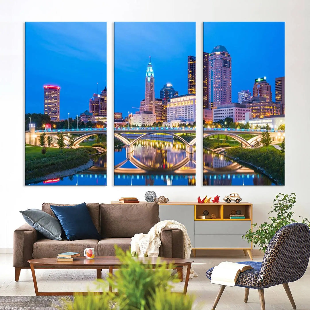 The modern living room is enhanced by the striking Columbus City Lights Bright Blue Skyline Cityscape View Wall Art Canvas Print displayed above white cabinets. This piece is crafted on museum-quality canvas with a UV-protective coating to ensure lasting beauty and vibrant colors.