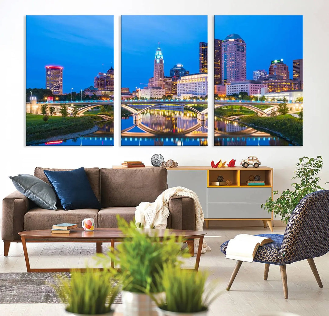 The modern living room is enhanced by the striking Columbus City Lights Bright Blue Skyline Cityscape View Wall Art Canvas Print displayed above white cabinets. This piece is crafted on museum-quality canvas with a UV-protective coating to ensure lasting beauty and vibrant colors.