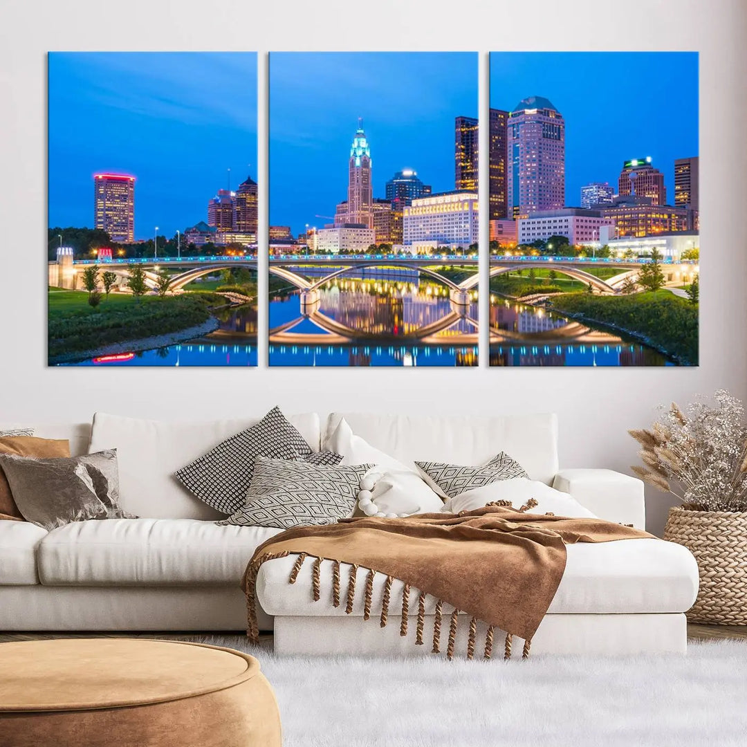 The modern living room is enhanced by the striking Columbus City Lights Bright Blue Skyline Cityscape View Wall Art Canvas Print displayed above white cabinets. This piece is crafted on museum-quality canvas with a UV-protective coating to ensure lasting beauty and vibrant colors.