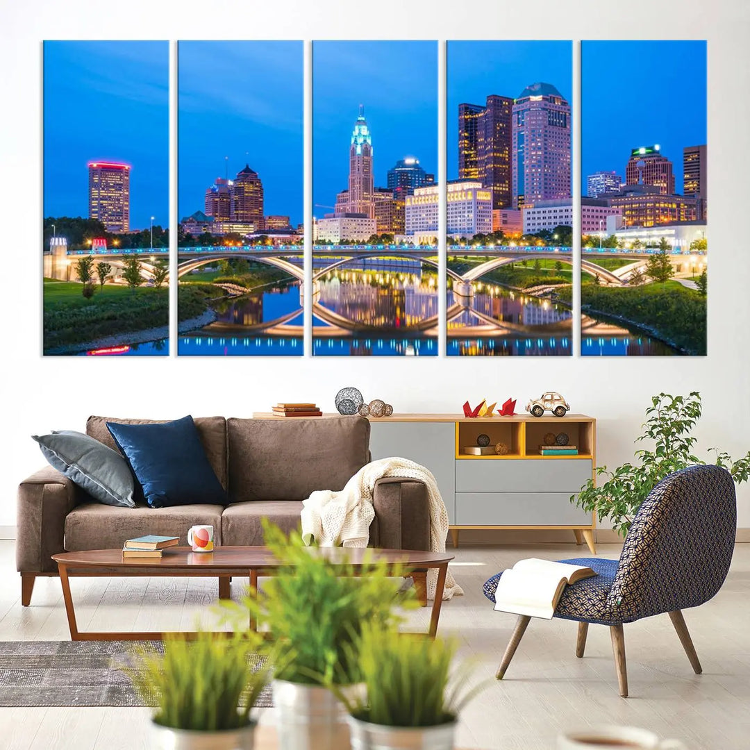 The modern living room is enhanced by the striking Columbus City Lights Bright Blue Skyline Cityscape View Wall Art Canvas Print displayed above white cabinets. This piece is crafted on museum-quality canvas with a UV-protective coating to ensure lasting beauty and vibrant colors.