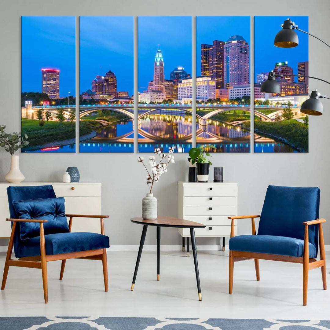 The modern living room is enhanced by the striking Columbus City Lights Bright Blue Skyline Cityscape View Wall Art Canvas Print displayed above white cabinets. This piece is crafted on museum-quality canvas with a UV-protective coating to ensure lasting beauty and vibrant colors.