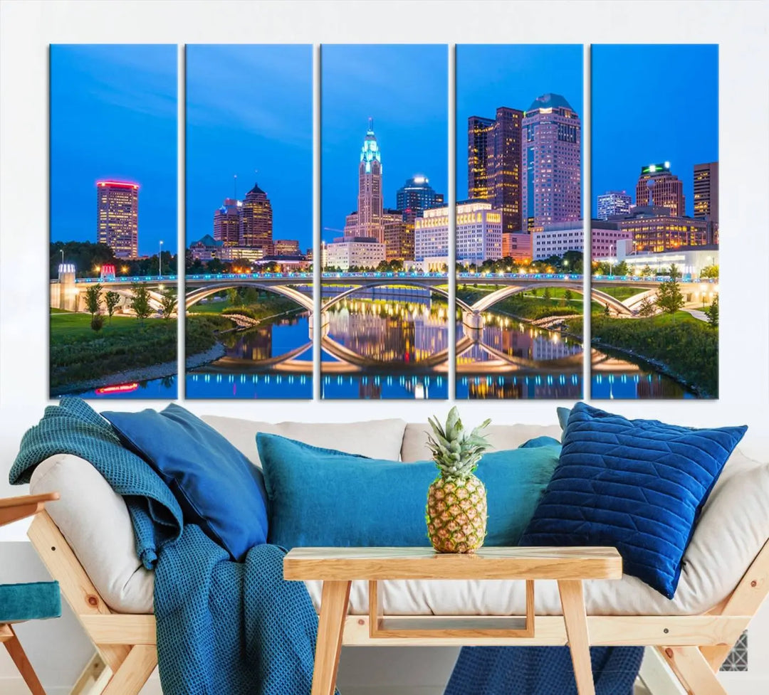 The modern living room is enhanced by the striking Columbus City Lights Bright Blue Skyline Cityscape View Wall Art Canvas Print displayed above white cabinets. This piece is crafted on museum-quality canvas with a UV-protective coating to ensure lasting beauty and vibrant colors.