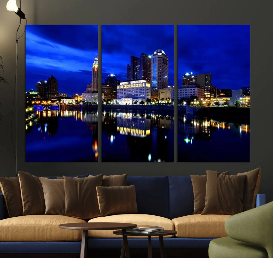 The living room showcases the Columbus City Lights Night Bright Blue Skyline Cityscape View Wall Art Canvas Print on a museum-quality canvas. The professionally hand-assembled artwork adds elegance while ensuring durable beauty.