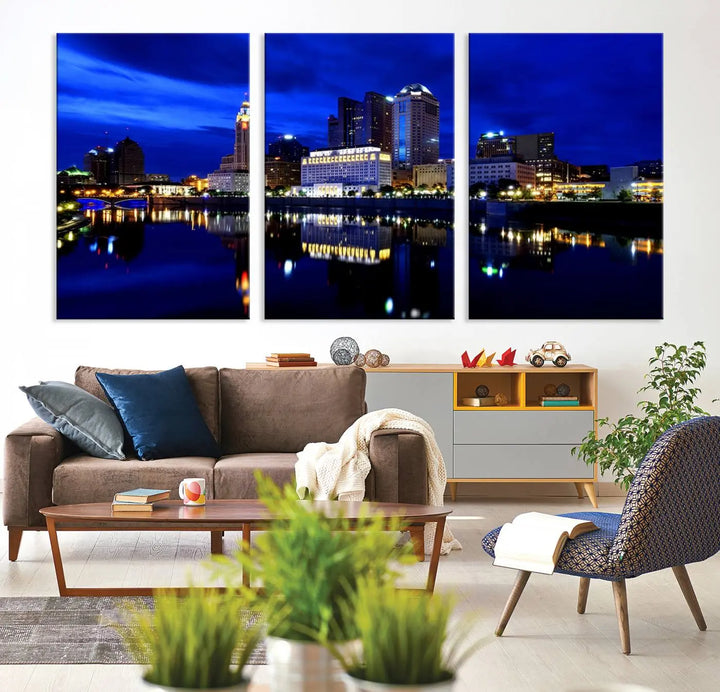 The living room showcases the Columbus City Lights Night Bright Blue Skyline Cityscape View Wall Art Canvas Print on a museum-quality canvas. The professionally hand-assembled artwork adds elegance while ensuring durable beauty.