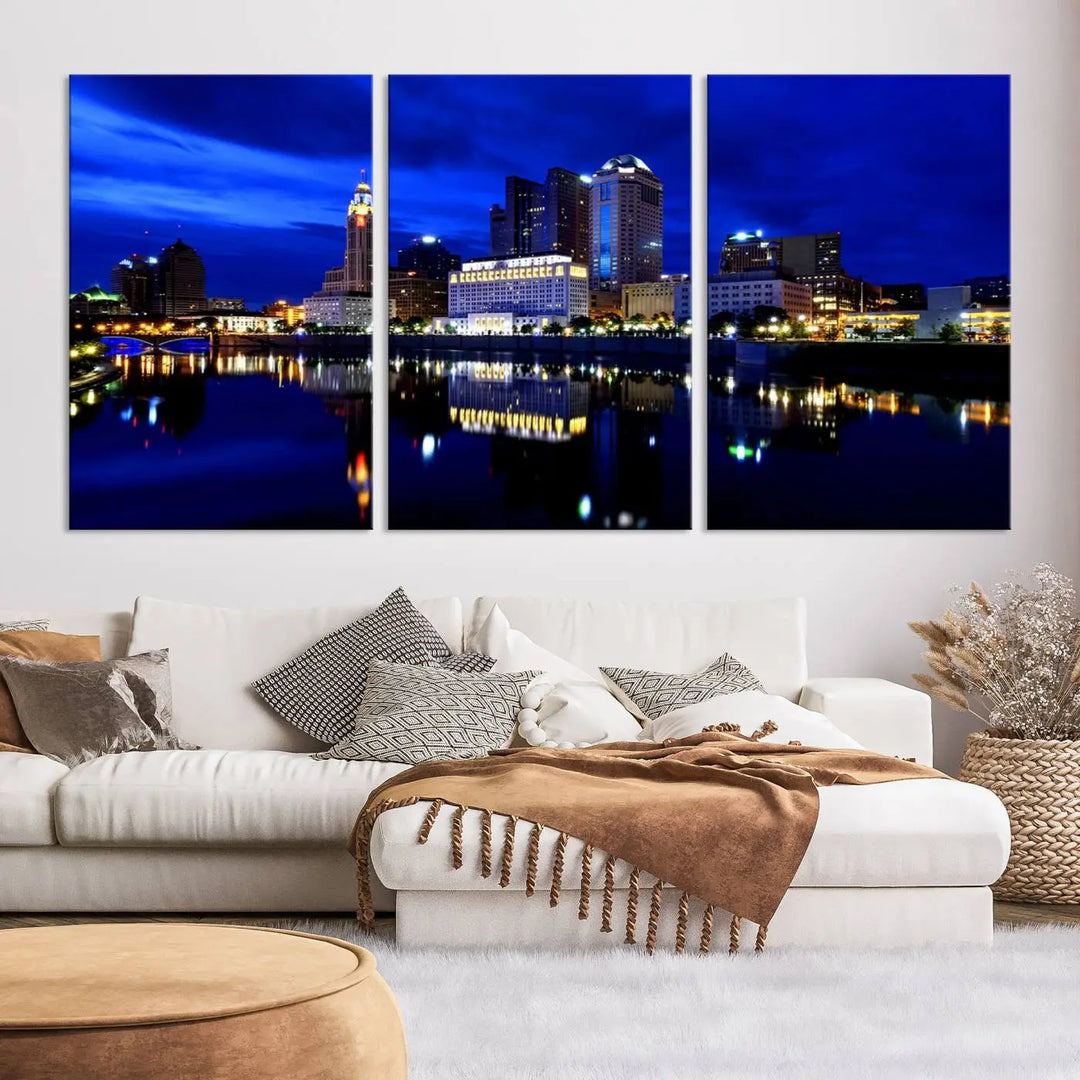 The living room showcases the Columbus City Lights Night Bright Blue Skyline Cityscape View Wall Art Canvas Print on a museum-quality canvas. The professionally hand-assembled artwork adds elegance while ensuring durable beauty.