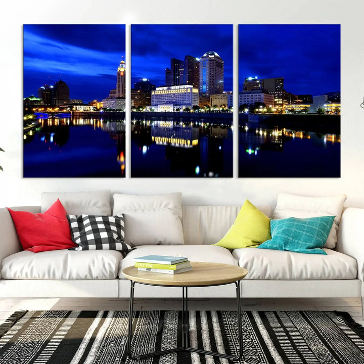 The living room showcases the Columbus City Lights Night Bright Blue Skyline Cityscape View Wall Art Canvas Print on a museum-quality canvas. The professionally hand-assembled artwork adds elegance while ensuring durable beauty.