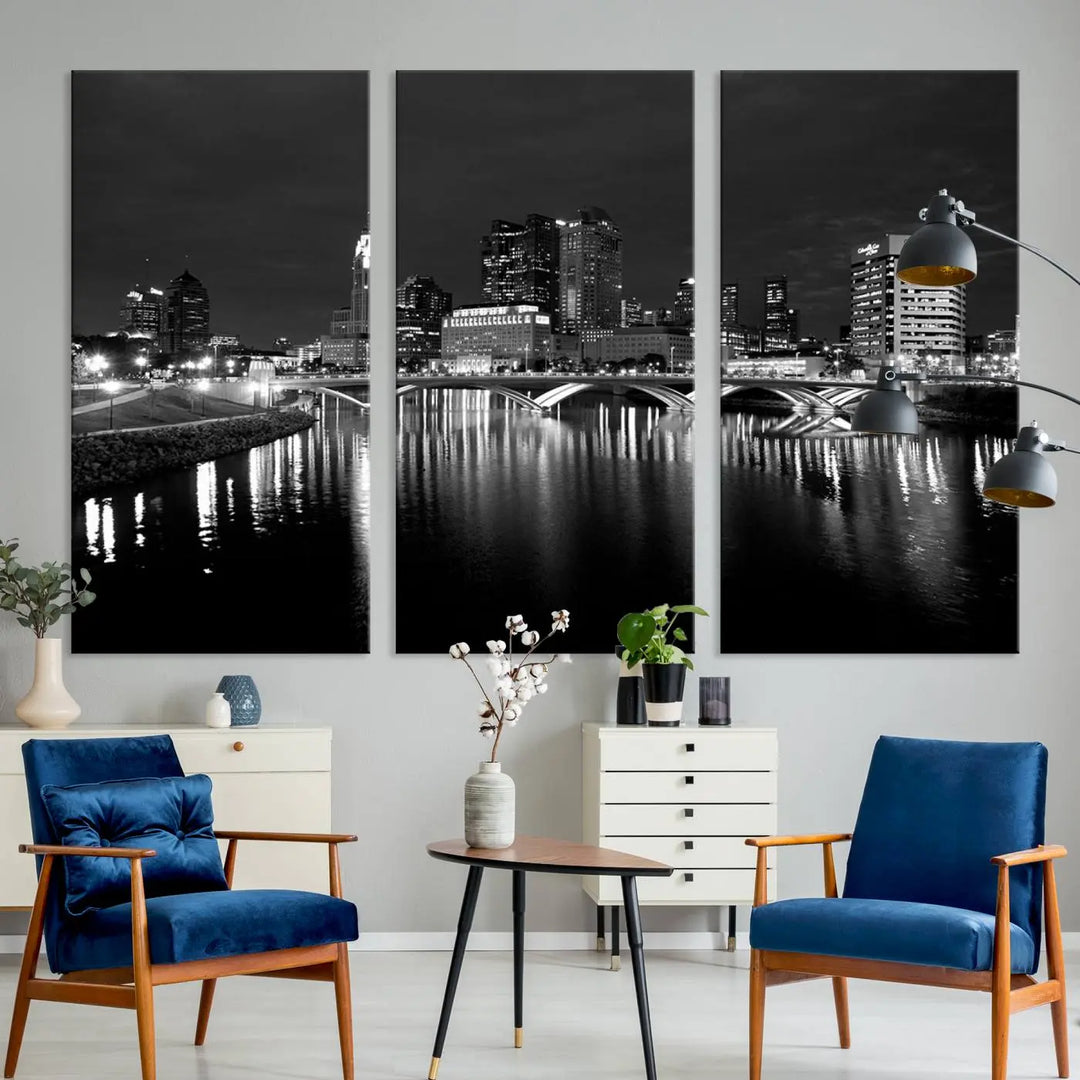 In a modern living room, the Columbus City Lights Skyline Black and White Wall Art cityscape canvas print elegantly adorns the wall above the couch. Its UV-protective coating ensures lasting elegance, and you can enjoy free shipping on this stylish centerpiece.