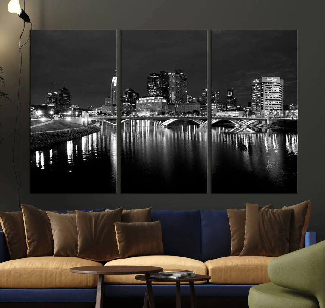 In a modern living room, the Columbus City Lights Skyline Black and White Wall Art cityscape canvas print elegantly adorns the wall above the couch. Its UV-protective coating ensures lasting elegance, and you can enjoy free shipping on this stylish centerpiece.