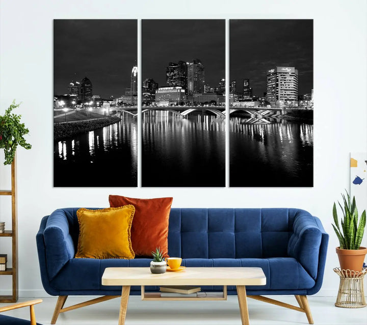 In a modern living room, the Columbus City Lights Skyline Black and White Wall Art cityscape canvas print elegantly adorns the wall above the couch. Its UV-protective coating ensures lasting elegance, and you can enjoy free shipping on this stylish centerpiece.