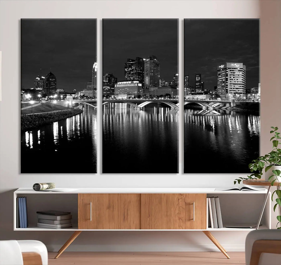 In a modern living room, the Columbus City Lights Skyline Black and White Wall Art cityscape canvas print elegantly adorns the wall above the couch. Its UV-protective coating ensures lasting elegance, and you can enjoy free shipping on this stylish centerpiece.