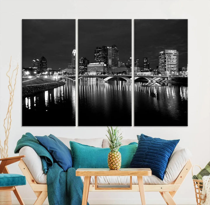 In a modern living room, the Columbus City Lights Skyline Black and White Wall Art cityscape canvas print elegantly adorns the wall above the couch. Its UV-protective coating ensures lasting elegance, and you can enjoy free shipping on this stylish centerpiece.