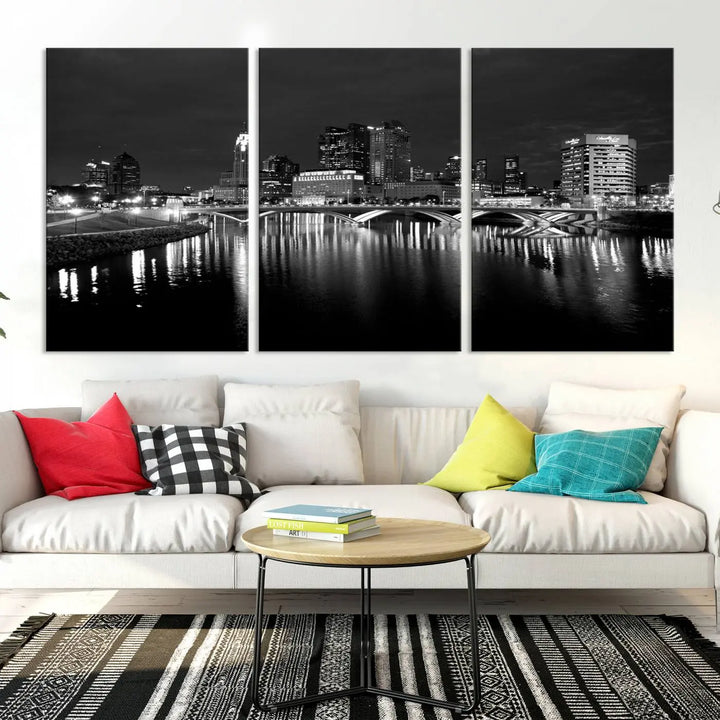 In a modern living room, the Columbus City Lights Skyline Black and White Wall Art cityscape canvas print elegantly adorns the wall above the couch. Its UV-protective coating ensures lasting elegance, and you can enjoy free shipping on this stylish centerpiece.