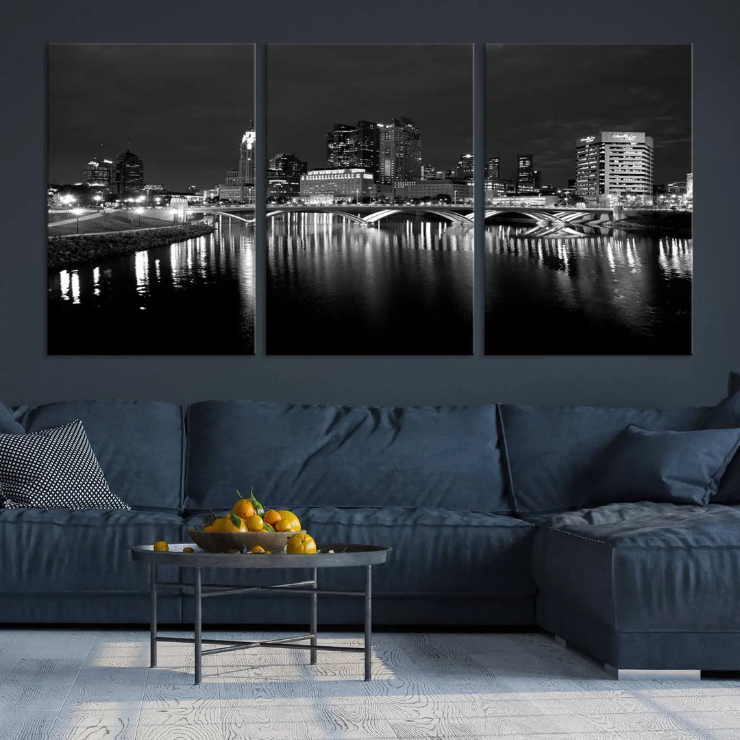 In a modern living room, the Columbus City Lights Skyline Black and White Wall Art cityscape canvas print elegantly adorns the wall above the couch. Its UV-protective coating ensures lasting elegance, and you can enjoy free shipping on this stylish centerpiece.