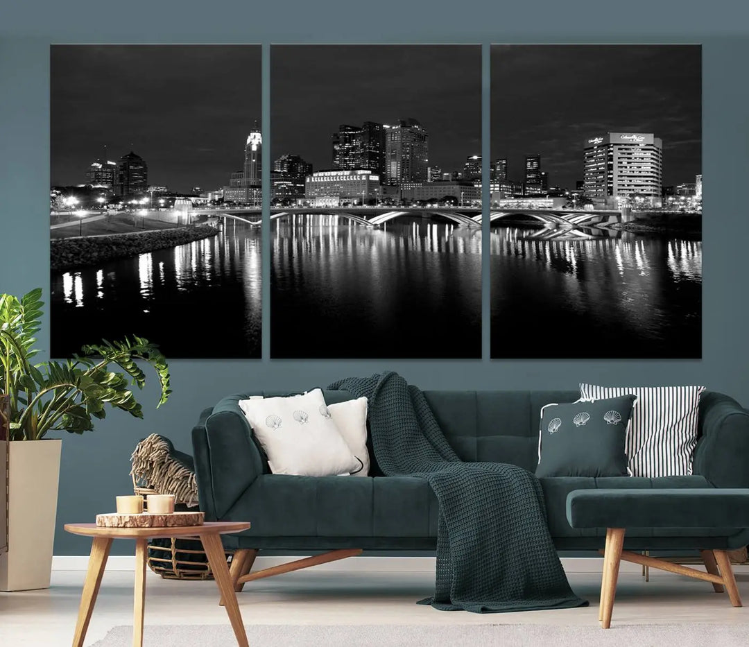 In a modern living room, the Columbus City Lights Skyline Black and White Wall Art cityscape canvas print elegantly adorns the wall above the couch. Its UV-protective coating ensures lasting elegance, and you can enjoy free shipping on this stylish centerpiece.