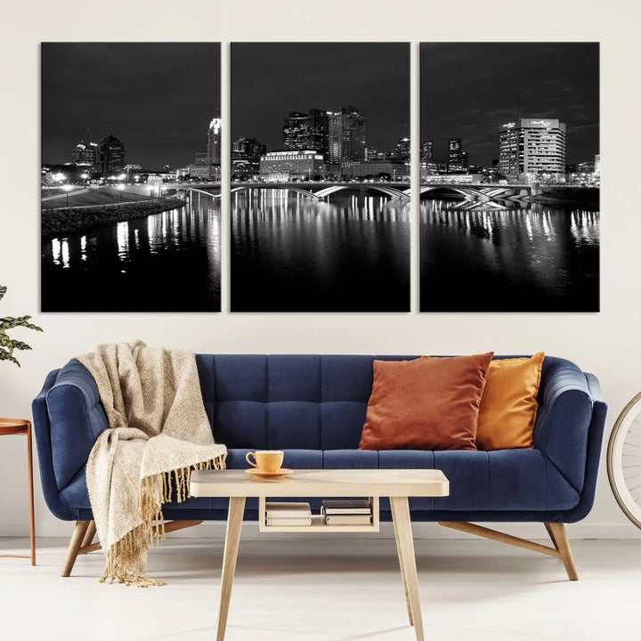 In a modern living room, the Columbus City Lights Skyline Black and White Wall Art cityscape canvas print elegantly adorns the wall above the couch. Its UV-protective coating ensures lasting elegance, and you can enjoy free shipping on this stylish centerpiece.