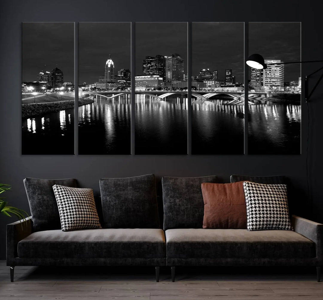 In a modern living room, the Columbus City Lights Skyline Black and White Wall Art cityscape canvas print elegantly adorns the wall above the couch. Its UV-protective coating ensures lasting elegance, and you can enjoy free shipping on this stylish centerpiece.