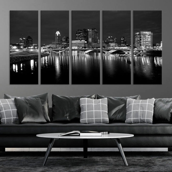 In a modern living room, the Columbus City Lights Skyline Black and White Wall Art cityscape canvas print elegantly adorns the wall above the couch. Its UV-protective coating ensures lasting elegance, and you can enjoy free shipping on this stylish centerpiece.