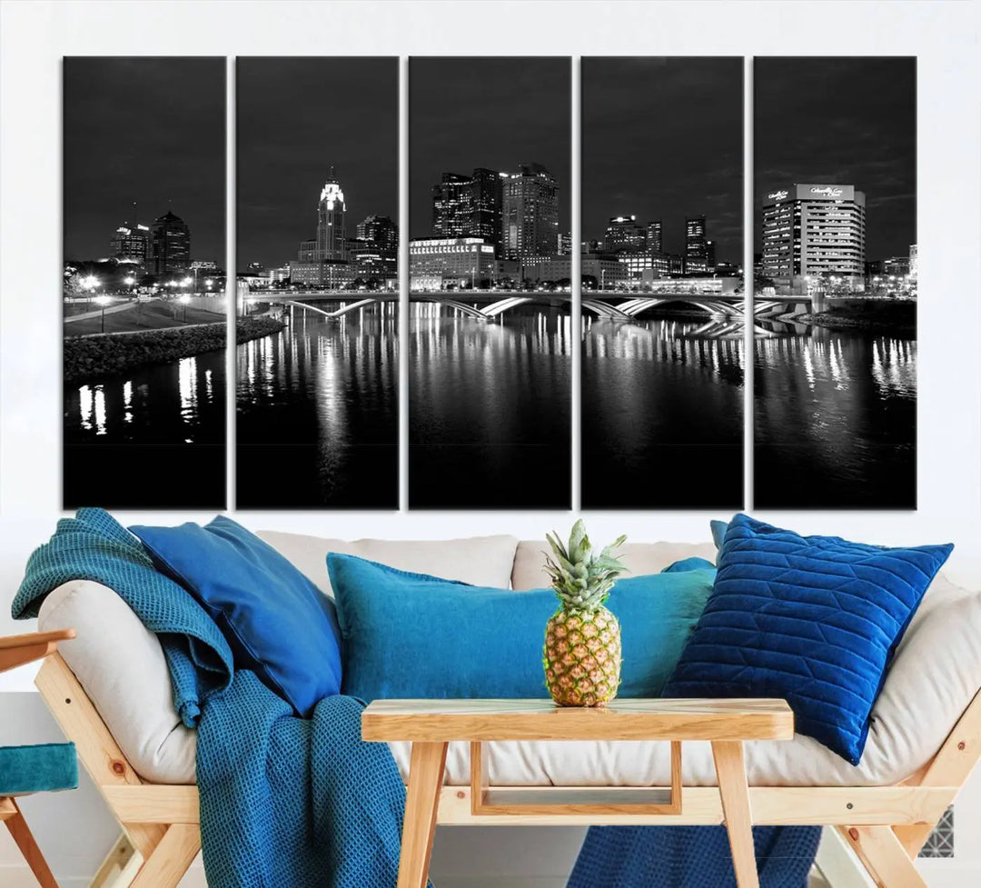 In a modern living room, the Columbus City Lights Skyline Black and White Wall Art cityscape canvas print elegantly adorns the wall above the couch. Its UV-protective coating ensures lasting elegance, and you can enjoy free shipping on this stylish centerpiece.