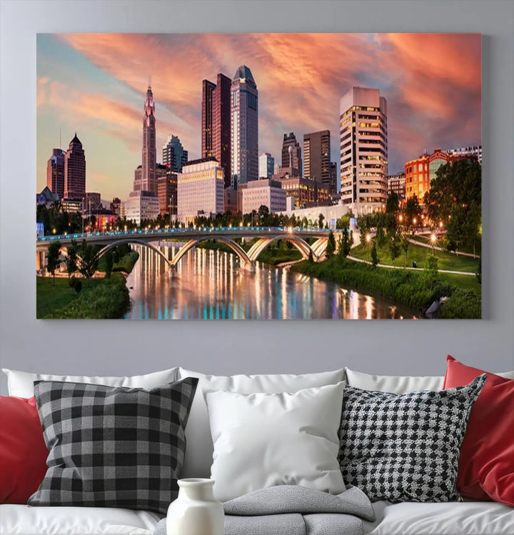 The "Columbus City Lights Sunset Orange Cloudy Skyline Cityscape View Wall Art Canvas Print" showcases a vibrant city skyline at sunset with a bridge spanning a river, strikingly displayed on museum-quality canvas.