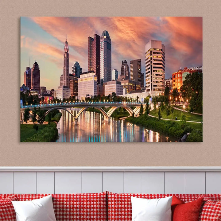 The "Columbus City Lights Sunset Orange Cloudy Skyline Cityscape View Wall Art Canvas Print" showcases a vibrant city skyline at sunset with a bridge spanning a river, strikingly displayed on museum-quality canvas.