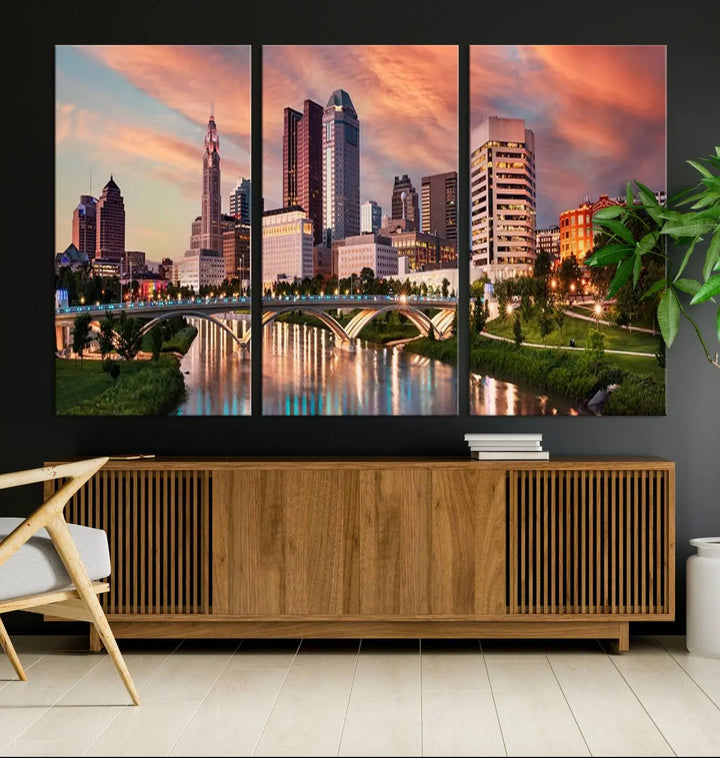 The "Columbus City Lights Sunset Orange Cloudy Skyline Cityscape View Wall Art Canvas Print" showcases a vibrant city skyline at sunset with a bridge spanning a river, strikingly displayed on museum-quality canvas.