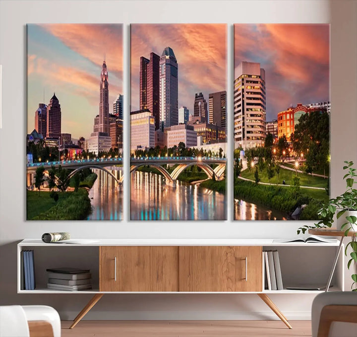 The "Columbus City Lights Sunset Orange Cloudy Skyline Cityscape View Wall Art Canvas Print" showcases a vibrant city skyline at sunset with a bridge spanning a river, strikingly displayed on museum-quality canvas.