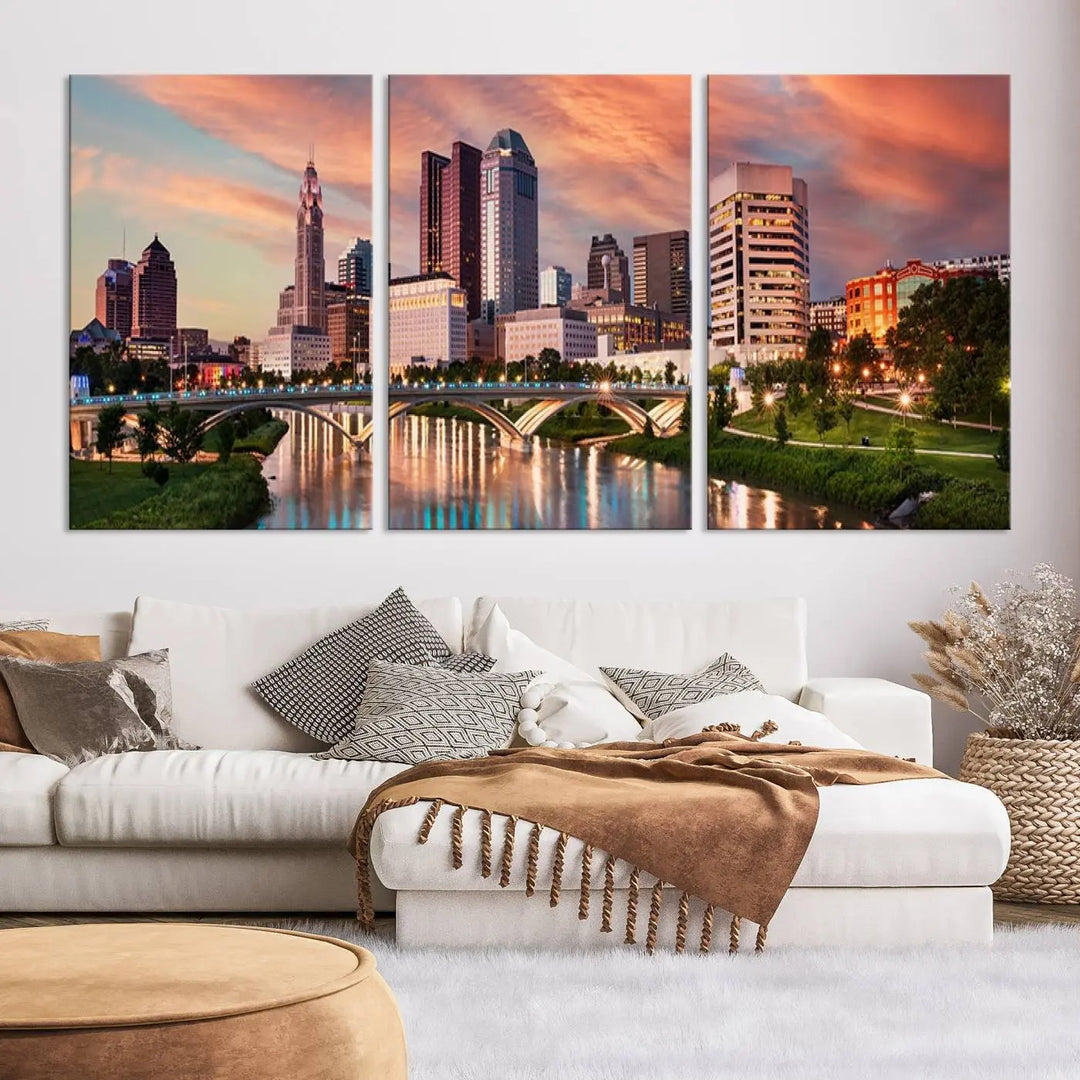 The "Columbus City Lights Sunset Orange Cloudy Skyline Cityscape View Wall Art Canvas Print" showcases a vibrant city skyline at sunset with a bridge spanning a river, strikingly displayed on museum-quality canvas.