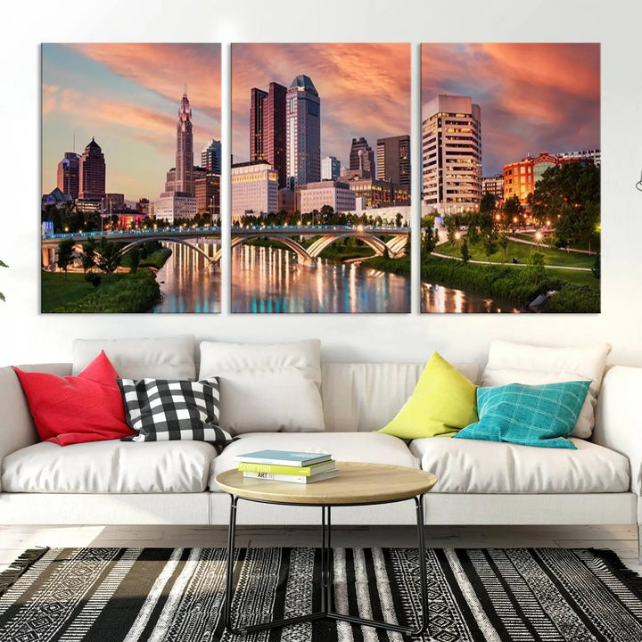 The "Columbus City Lights Sunset Orange Cloudy Skyline Cityscape View Wall Art Canvas Print" showcases a vibrant city skyline at sunset with a bridge spanning a river, strikingly displayed on museum-quality canvas.