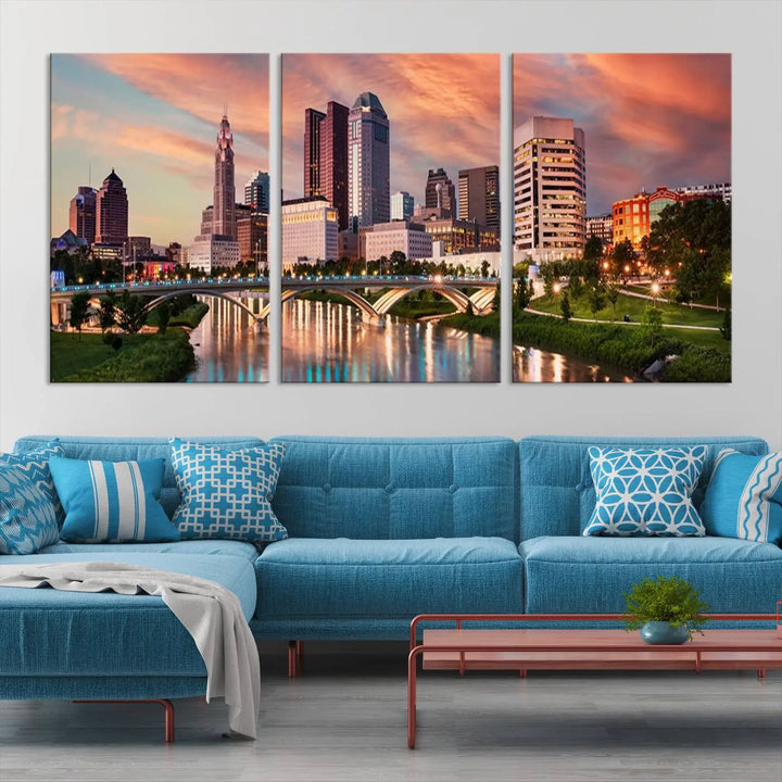 The "Columbus City Lights Sunset Orange Cloudy Skyline Cityscape View Wall Art Canvas Print" showcases a vibrant city skyline at sunset with a bridge spanning a river, strikingly displayed on museum-quality canvas.