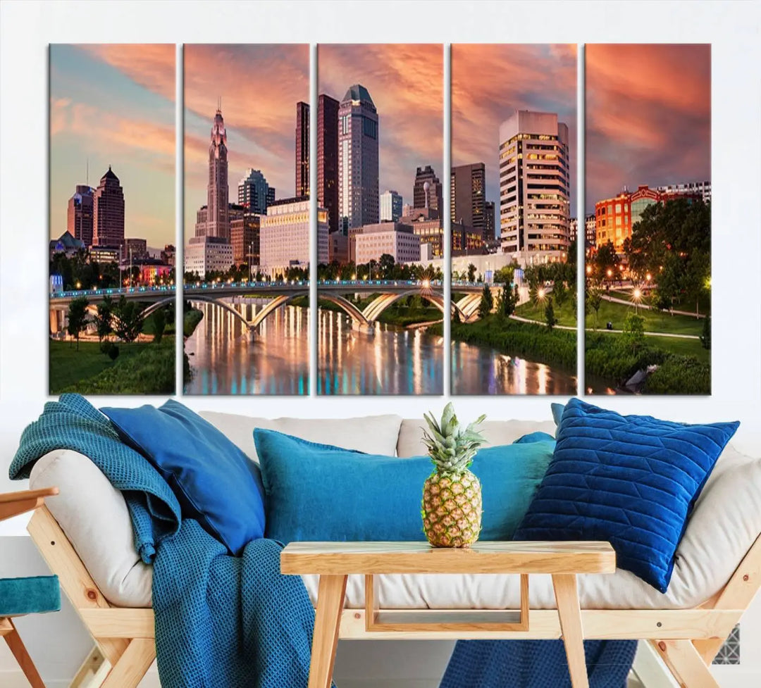 The "Columbus City Lights Sunset Orange Cloudy Skyline Cityscape View Wall Art Canvas Print" showcases a vibrant city skyline at sunset with a bridge spanning a river, strikingly displayed on museum-quality canvas.