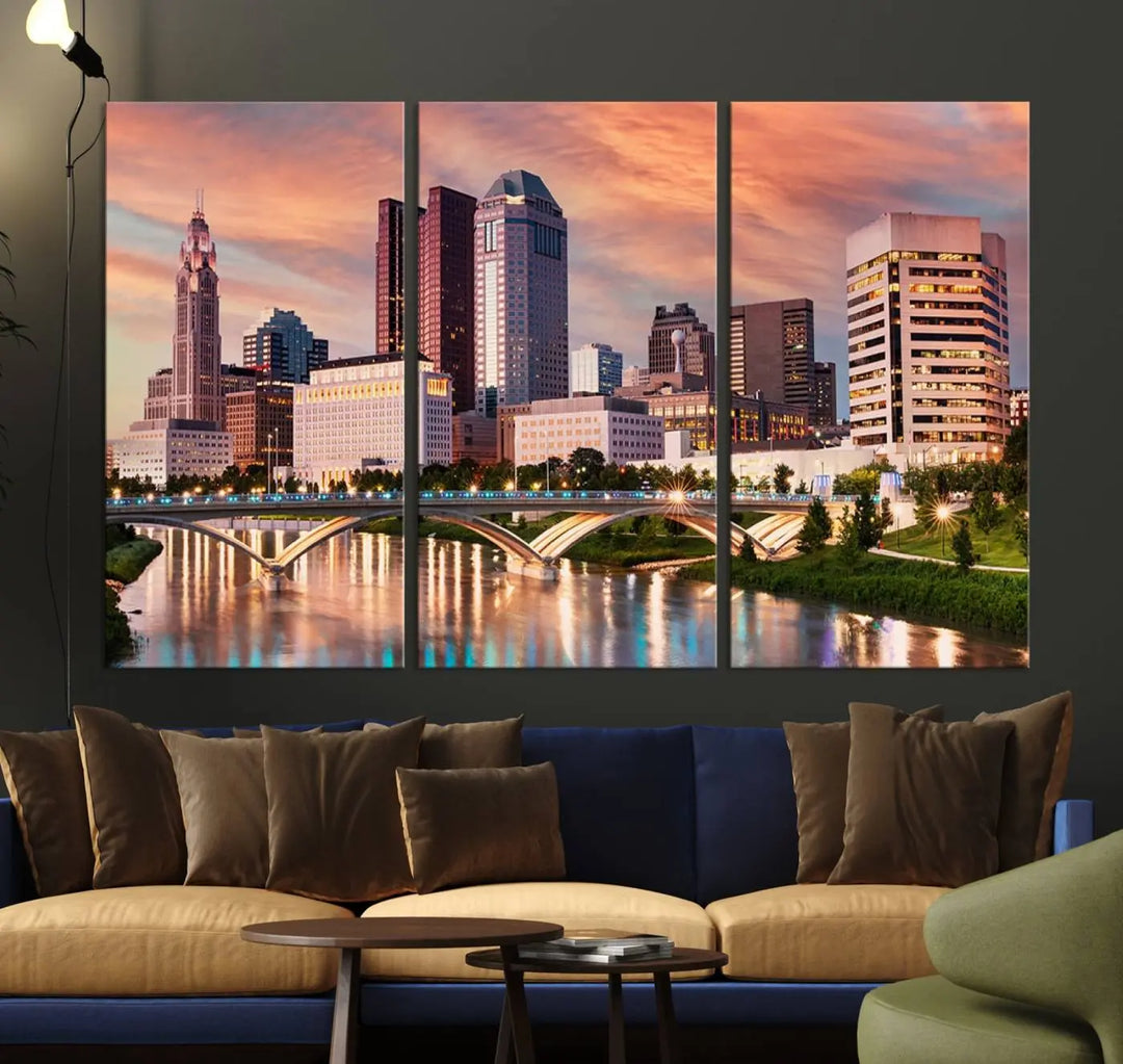 The "Columbus City Lights Sunset Orange Cloudy Skyline Cityscape View" wall art is featured on the wall. This triptych is printed on museum-quality canvas and includes a UV-protective coating, ensuring lasting vibrancy.