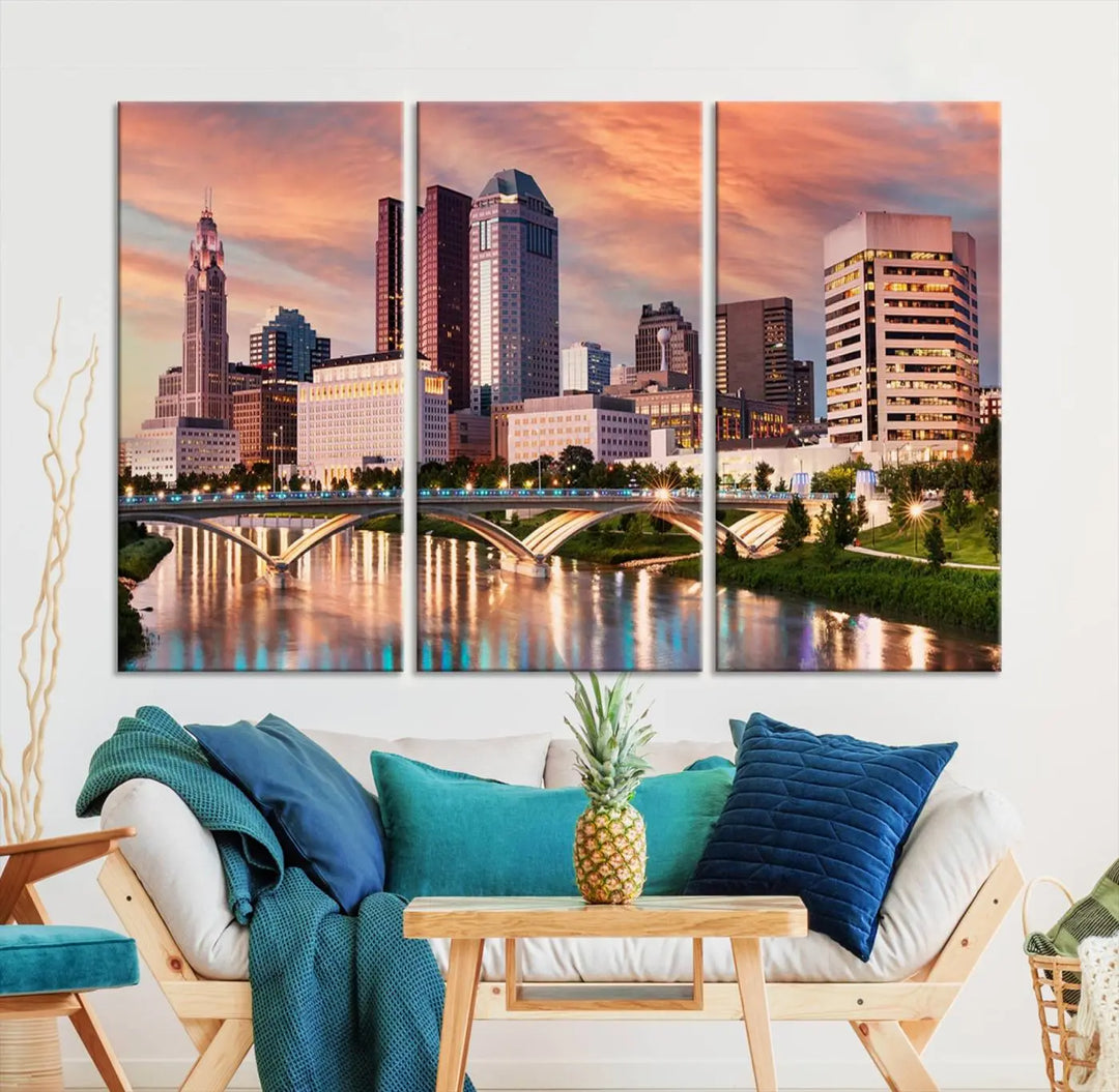 The "Columbus City Lights Sunset Orange Cloudy Skyline Cityscape View" wall art is featured on the wall. This triptych is printed on museum-quality canvas and includes a UV-protective coating, ensuring lasting vibrancy.