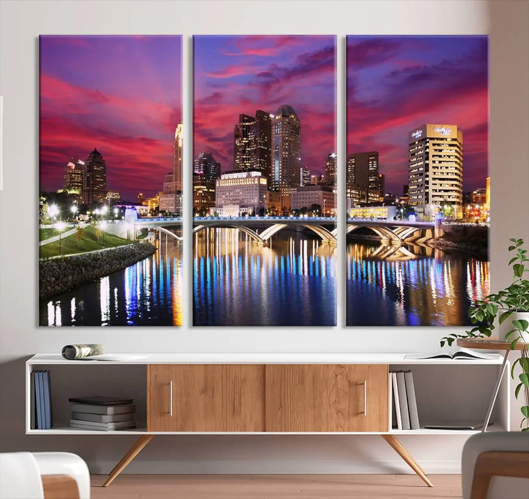 The "Columbus City Lights Sunset Pink and Purple Cloudy Skyline Cityscape View Wall Art Canvas Print" captures the beauty of a city skyline at dusk with its reflection on the river. Crafted on museum-quality canvas with a UV-protective coating, this triptych wall art is ready to hang and adds an elegant touch to any room.