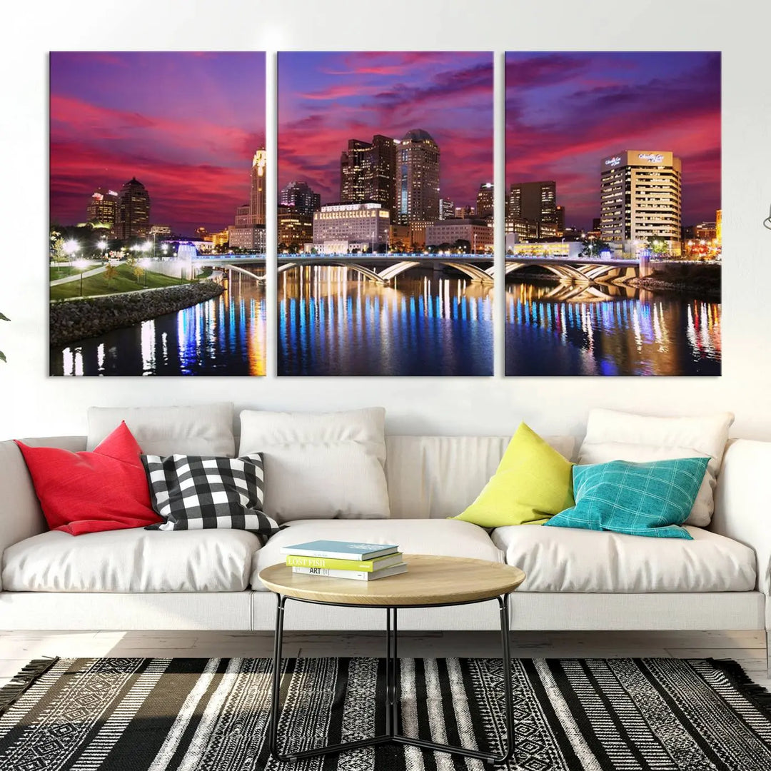 The "Columbus City Lights Sunset Pink and Purple Cloudy Skyline Cityscape View Wall Art Canvas Print" captures the beauty of a city skyline at dusk with its reflection on the river. Crafted on museum-quality canvas with a UV-protective coating, this triptych wall art is ready to hang and adds an elegant touch to any room.