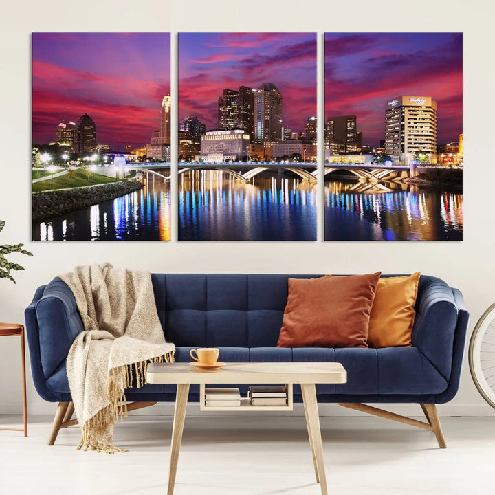 The "Columbus City Lights Sunset Pink and Purple Cloudy Skyline Cityscape View Wall Art Canvas Print" captures the beauty of a city skyline at dusk with its reflection on the river. Crafted on museum-quality canvas with a UV-protective coating, this triptych wall art is ready to hang and adds an elegant touch to any room.