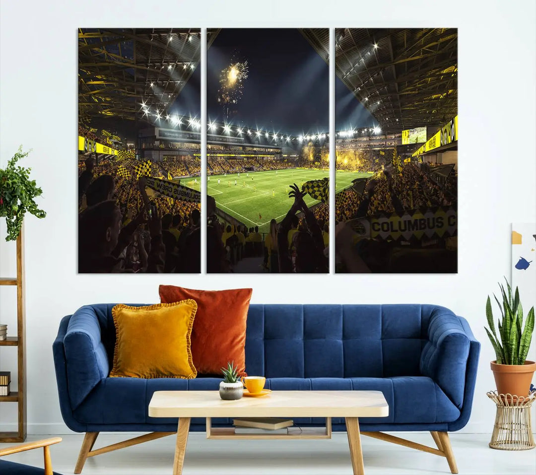 The wall of a modern living room is adorned with a triptych canvas titled "Columbus Crew Soccer Team Print," capturing the vibrant energy of the Columbus Crew Stadium in high-resolution printing.