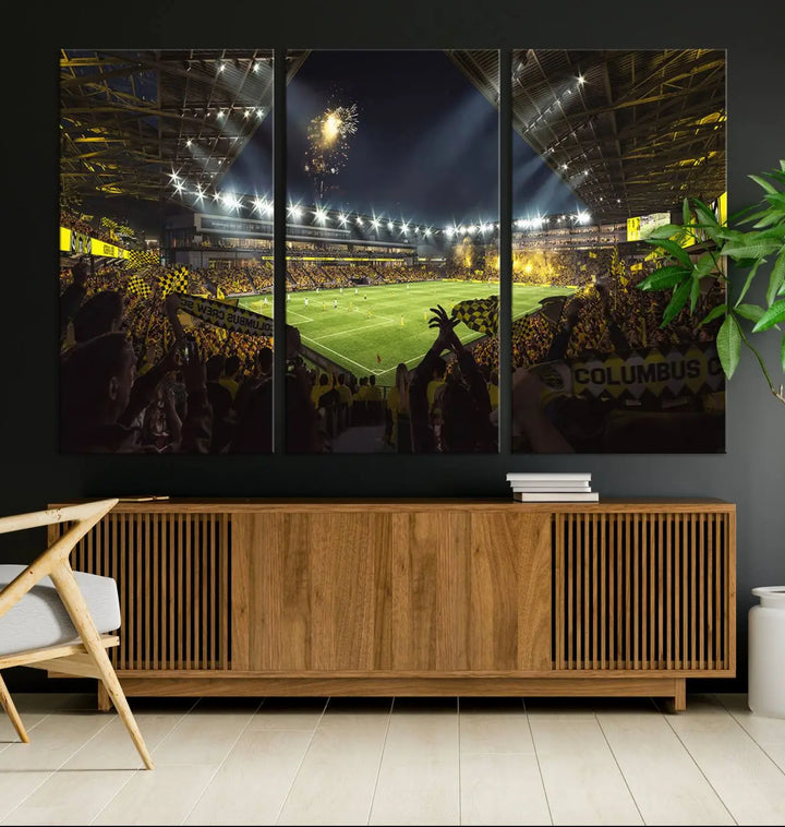 The wall of a modern living room is adorned with a triptych canvas titled "Columbus Crew Soccer Team Print," capturing the vibrant energy of the Columbus Crew Stadium in high-resolution printing.