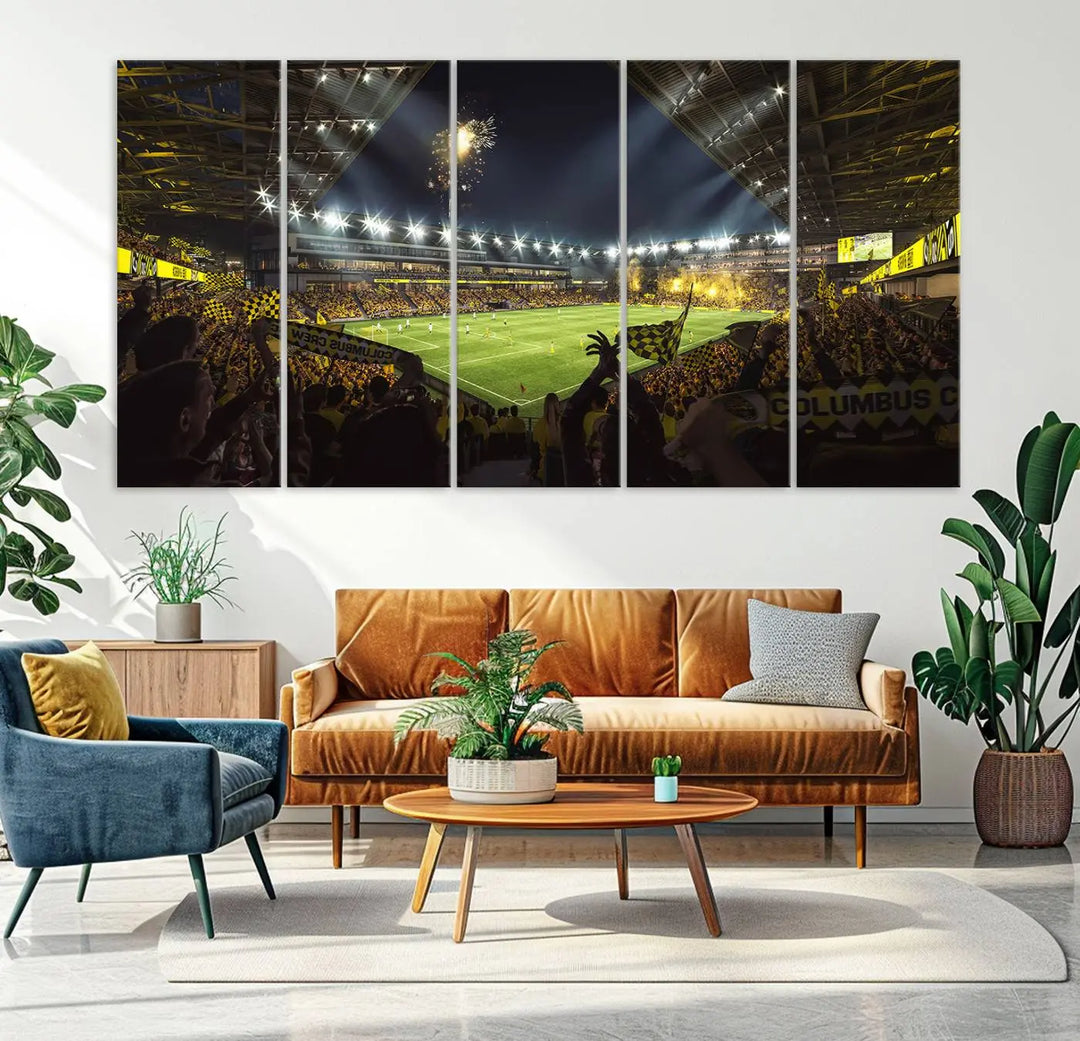 The wall of a modern living room is adorned with a triptych canvas titled "Columbus Crew Soccer Team Print," capturing the vibrant energy of the Columbus Crew Stadium in high-resolution printing.