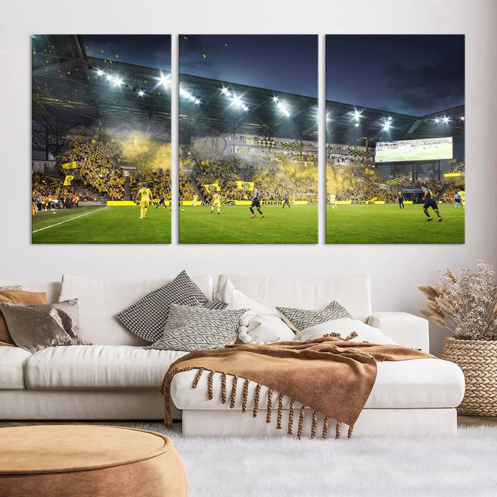 The Columbus Crew Stadium Match Triple Canvas Wall Art, featuring a dynamic MLS game scene, captures the excitement of a thrilling soccer match with stadium lights illuminating the field and crowd.