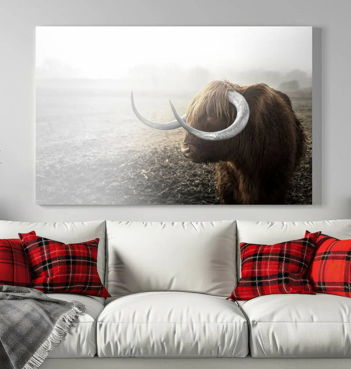 A captivating Cow Wall Art Canvas Print featuring a Highland cow with impressive horns in a misty field, crafted on museum-quality canvas. Its UV-protective coating preserves the artwork's vibrant colors.