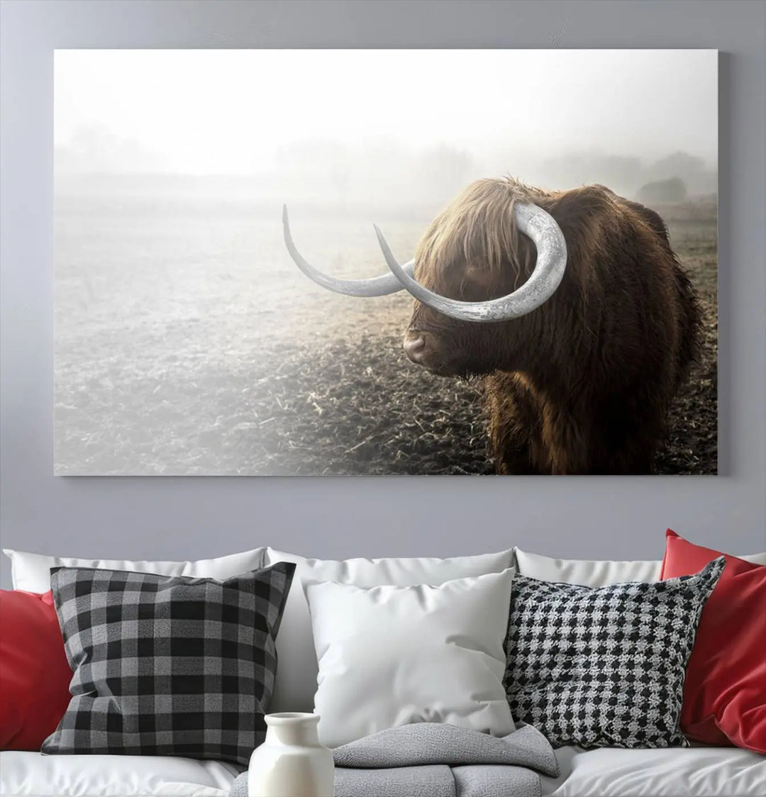 A captivating Cow Wall Art Canvas Print featuring a Highland cow with impressive horns in a misty field, crafted on museum-quality canvas. Its UV-protective coating preserves the artwork's vibrant colors.