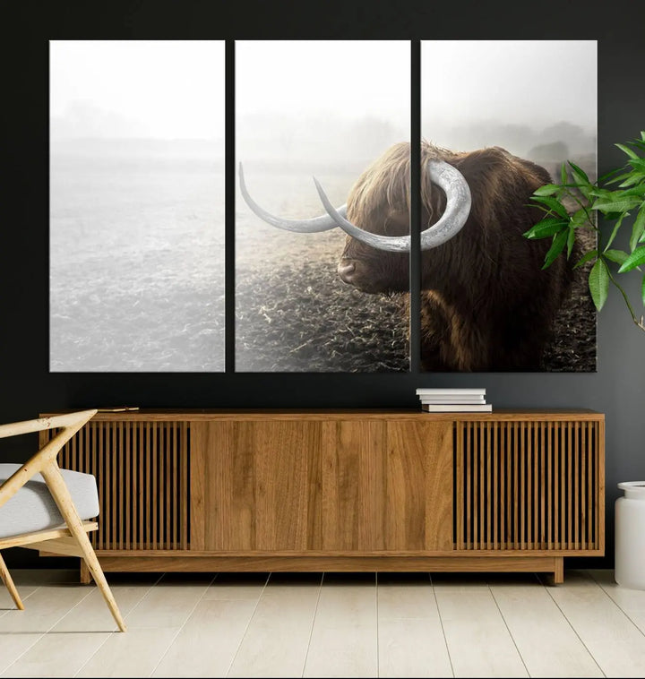 A captivating Cow Wall Art Canvas Print featuring a Highland cow with impressive horns in a misty field, crafted on museum-quality canvas. Its UV-protective coating preserves the artwork's vibrant colors.